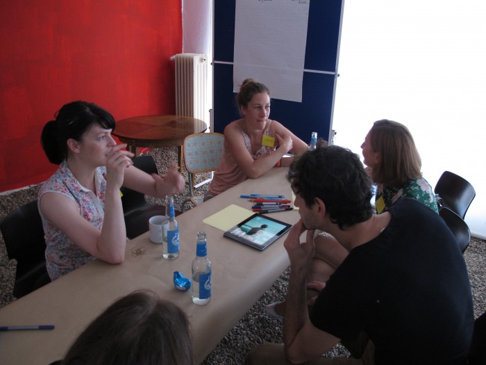 Inmitten einer Installation aus Schottersteinen beraten Saskia Behrens und ihre Teilnehmer.