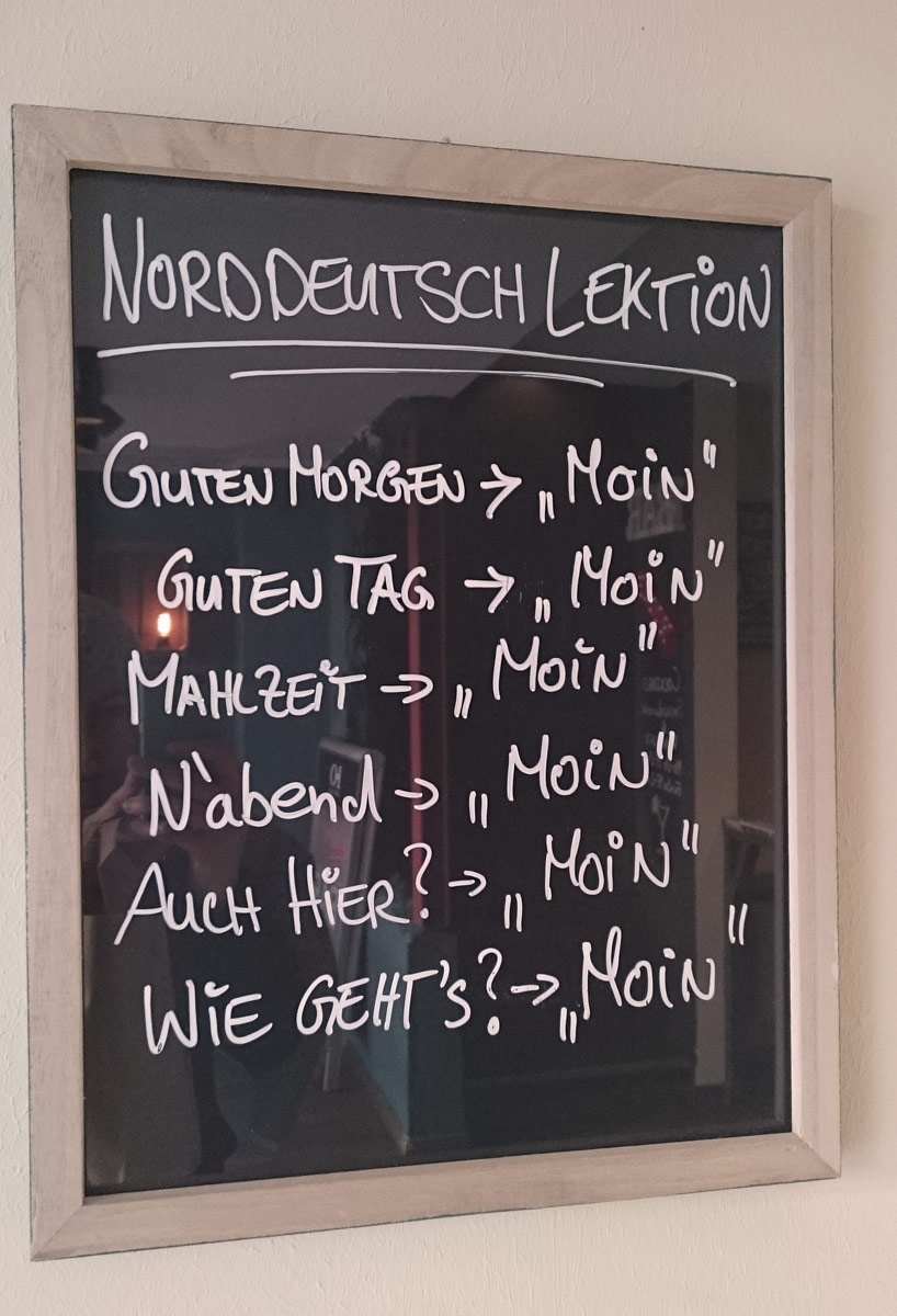Norddeutsche Sprachlektüre im Bilderrahmen beim Bremer Café Brill No. 6: Moin geht immer.